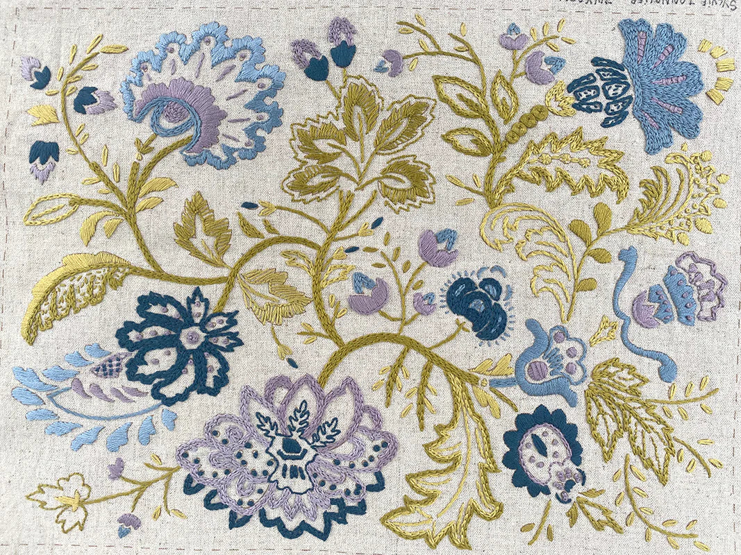 Decorative floral pattern with blue, purple, and gold colors on a textured background.