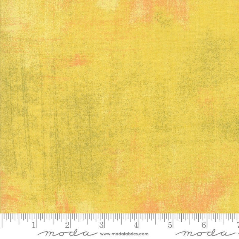 A swatch of textured-effect yellow blender quilt fabric.