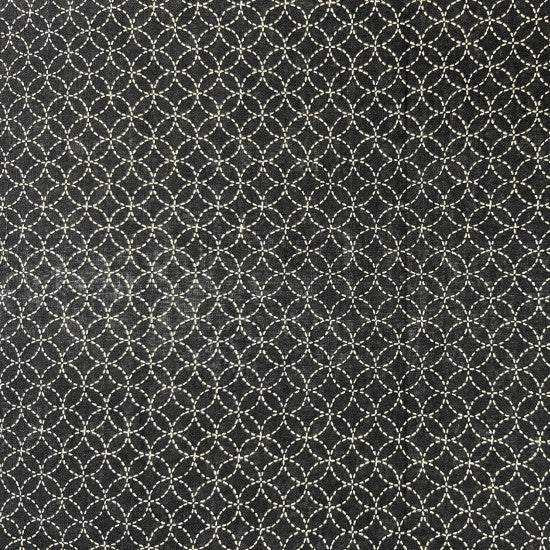 A close-up image of a black cotton fabric with a small white geometric design.