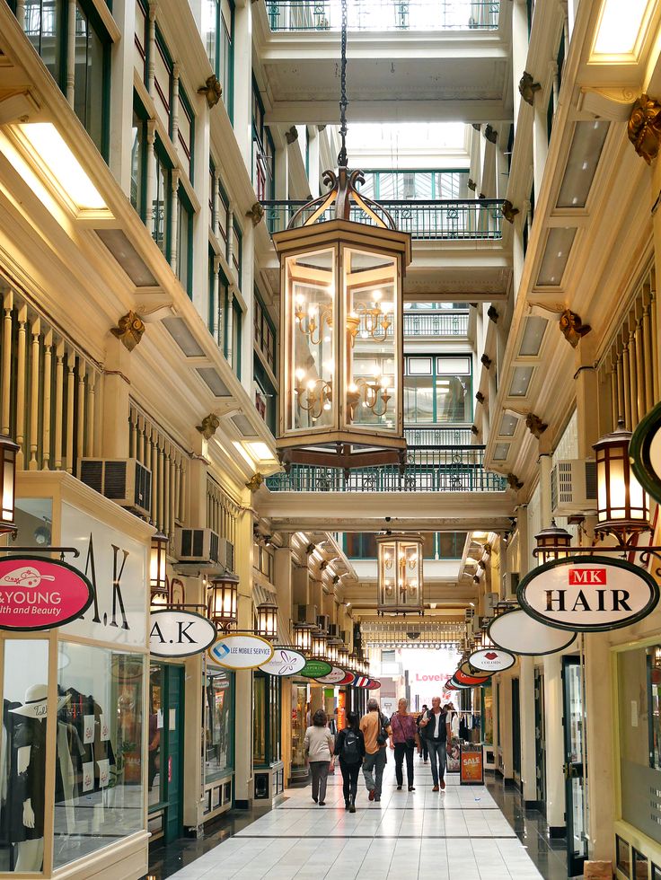 Interior of a shopping mall with people walking and various shops.