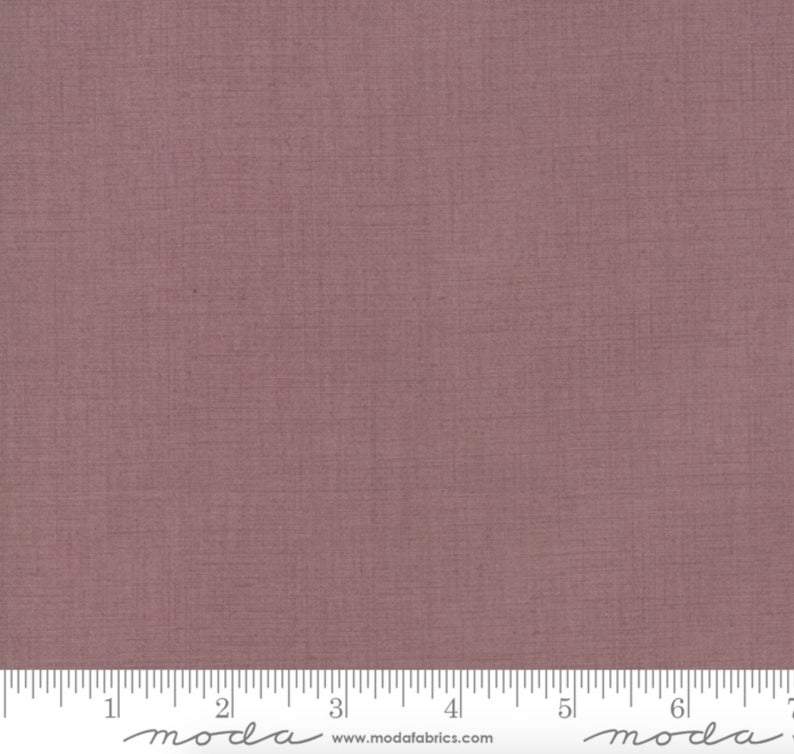 A solid lavender-colored blender quilting fabric from the French General collection.