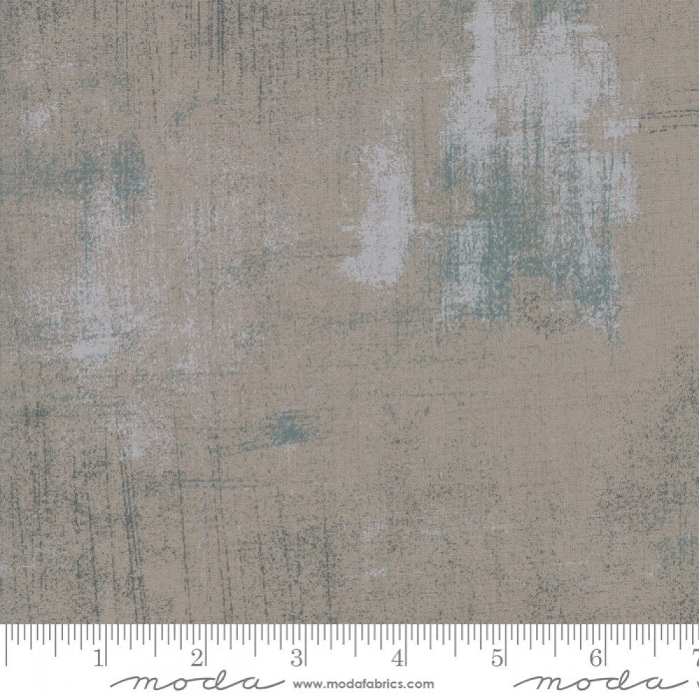 A swatch of quilting fabric with a textured dark grey design with metallic accents.