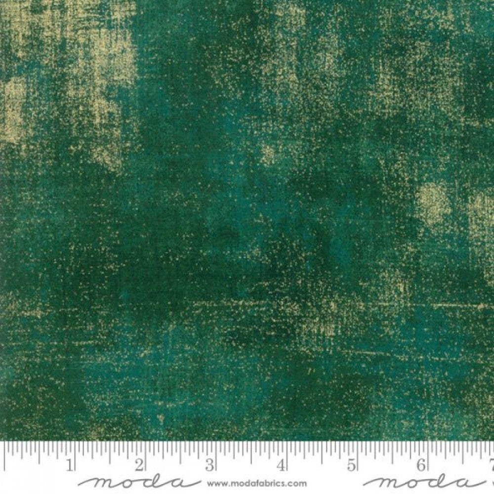 A swatch of quilting fabric with a textured green design and metallic accents.