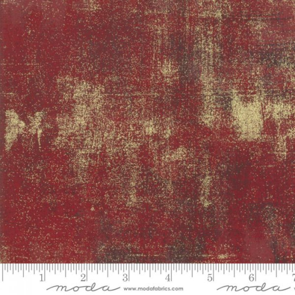 A swatch of red and metallic berry design quilting fabric.