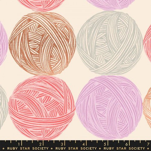 A cotton canvas weight swatch of fabric with balls of yarn in shades of pink, brown, and white.