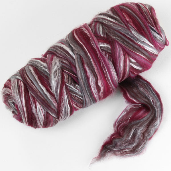 Picture of a batt of New Zealand Merino and Silk unspun fibre dyed in multi-colour storm purples and reds