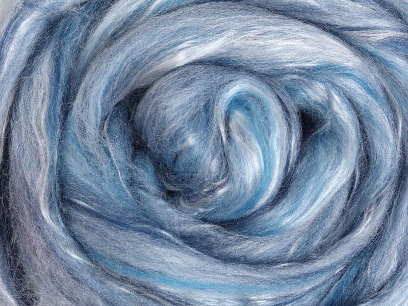 Close up picture of a sample of New Zealand Merino and Silk unspun fibre dyed in multi-colour sky blues