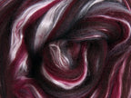 Close up picture of a sample of New Zealand Merino and Silk unspun fibre dyed in multi-colour storm purples and reds