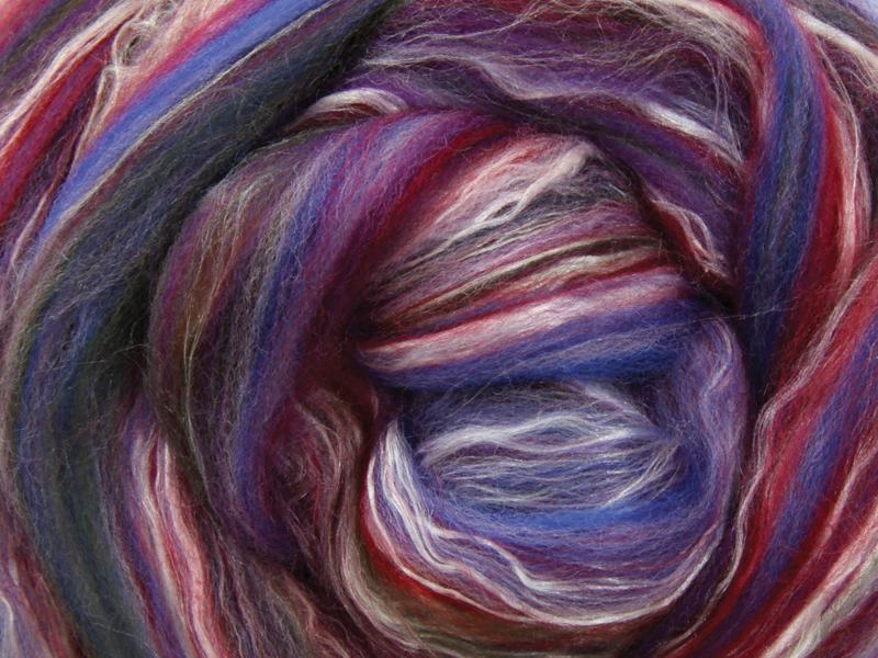 Close up picture of a sample of New Zealand Merino and Silk unspun fibre dyed in multi-colour jewel tones purples greens and blues