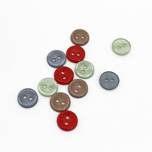 An assortment of colorful two-hole polyester buttons arranged on a white background.