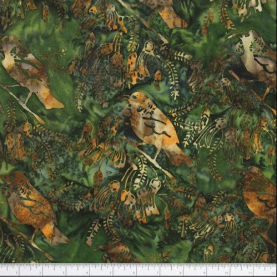 A close-up of patterned fabric featuring Tui birds and foliage in green, brown, tan, and peach tones, with a white ruler along the bottom edge for scale.