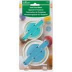 Pom-pom maker packaging with two circular cutters on a white background