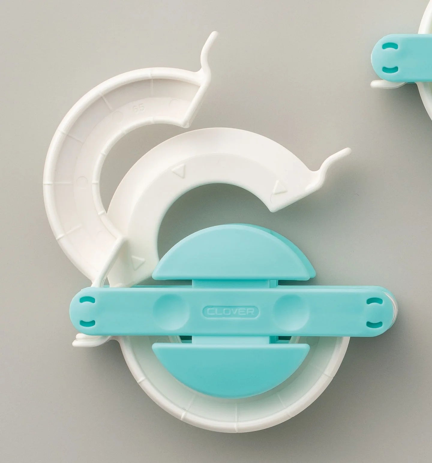 Close up of pom pom maker on a gray background