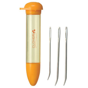 Clover needle case with orange lid and bottom, containing needles on a white background