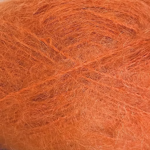 Close-up of rusty orange yarn with a fluffy mohair texture