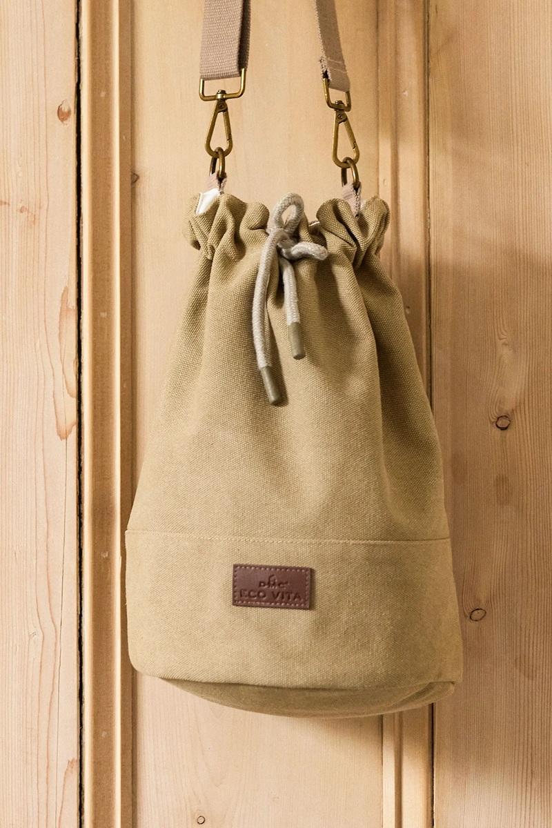 Khaki craft drawstring bag with a brand label on a wooden surface