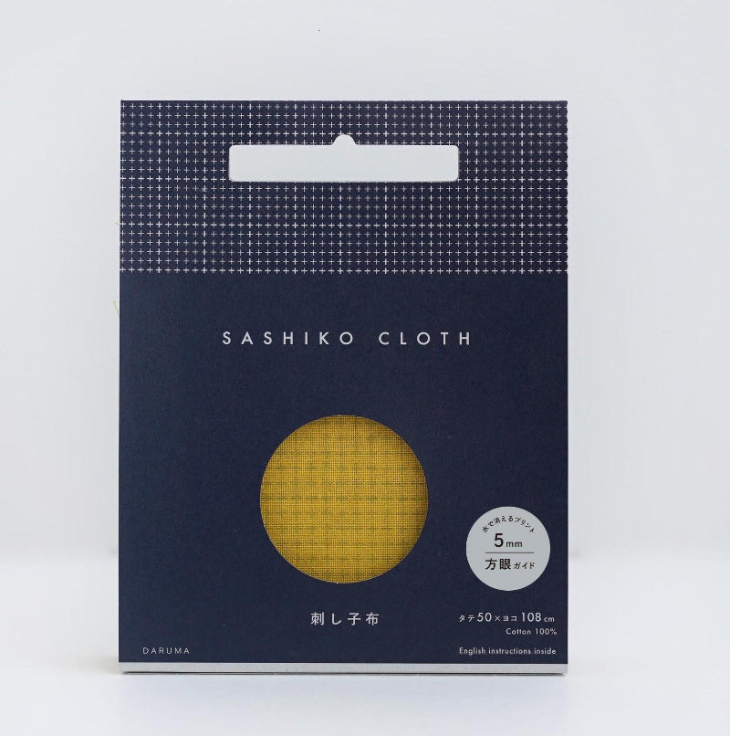 Package of Sashiko cloth with a mustard yellow fabric sample in a dark blue package