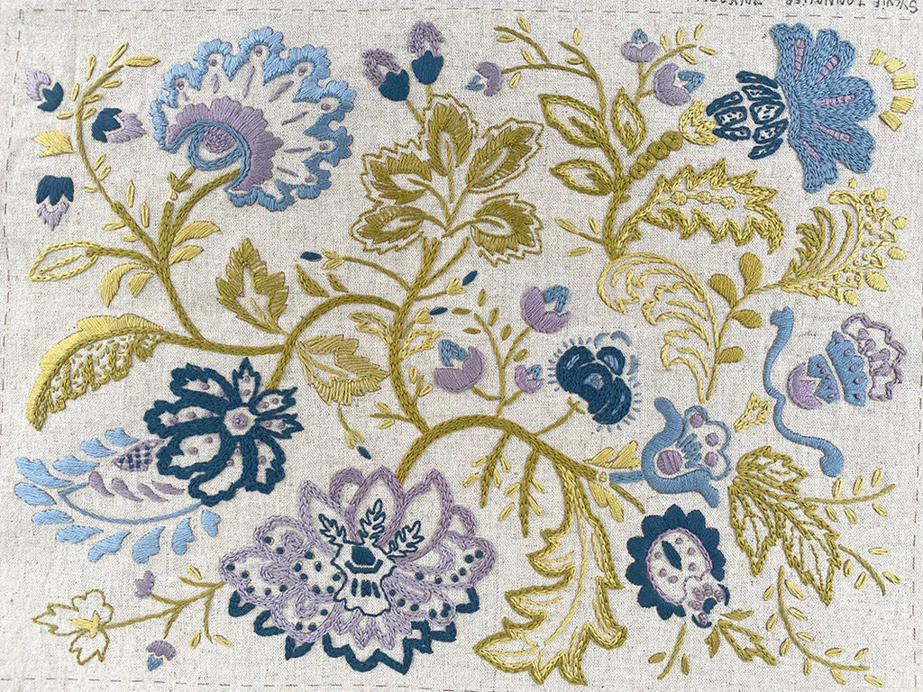Decorative floral pattern with blue, purple, and gold colors on a textured background.