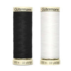 Two spools of Gutermann thread, one black and one white, on a white background.