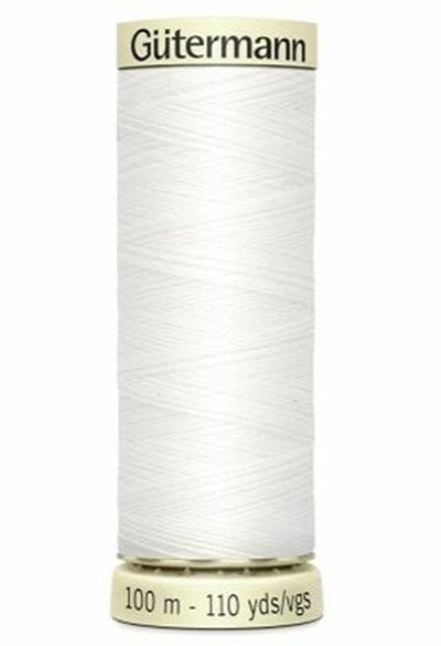 Spool of white thread with 'Gutermann' branding on a white background