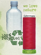 Bottle labeled '100% recycled' next to a spool of red thread with 'Gütermann' branding on a green background.