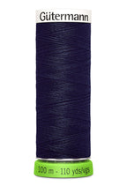 Spool of navy Gutermann thread on a white background