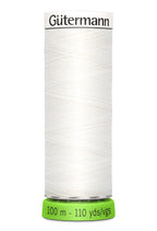 Spool of white thread  'Gäutermann' branding on a white background