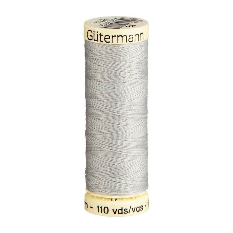 Spool of light grey thread with 'Gutermann' branding on a white background