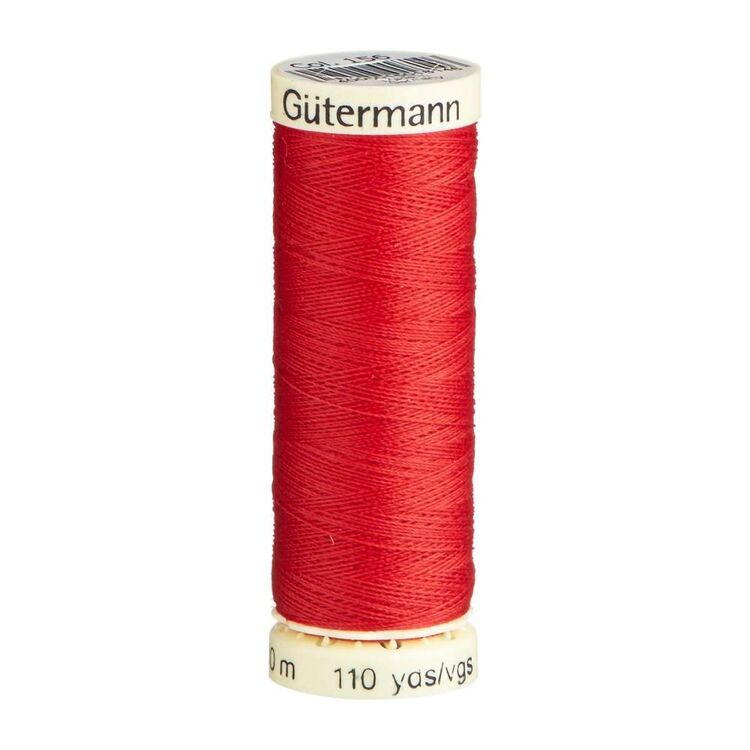 Spool of scarlet red thread with 'Gutermann' branding on a white background