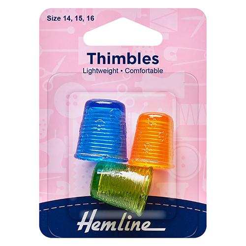 Packaged thimbles with blue, orange, and green colors on a pink background with 'Hemline' branding.