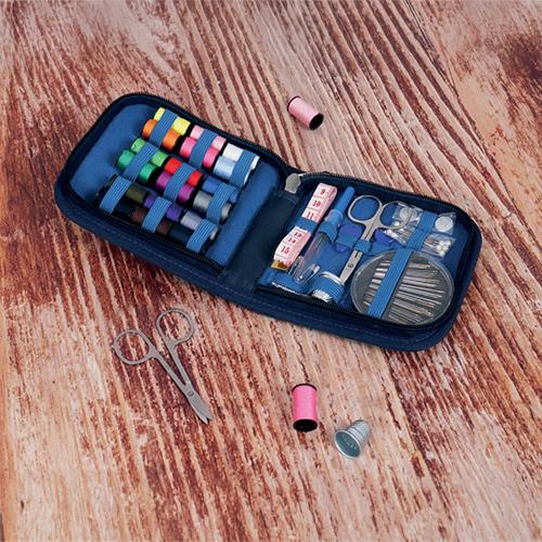 Sewing kit with various tools on a wooden surface