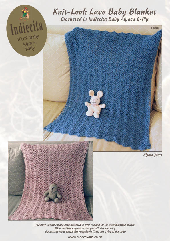 A crochet lace baby blanket in blue and pink colors with a small toy rabbit placed on top.