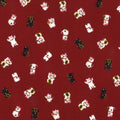 A fabric with a Japanese design featuring multi-coloured lucky cats on a linen-look red background.