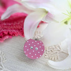 Pink polka dot row counter for knitting or crochet on a table with ribbons