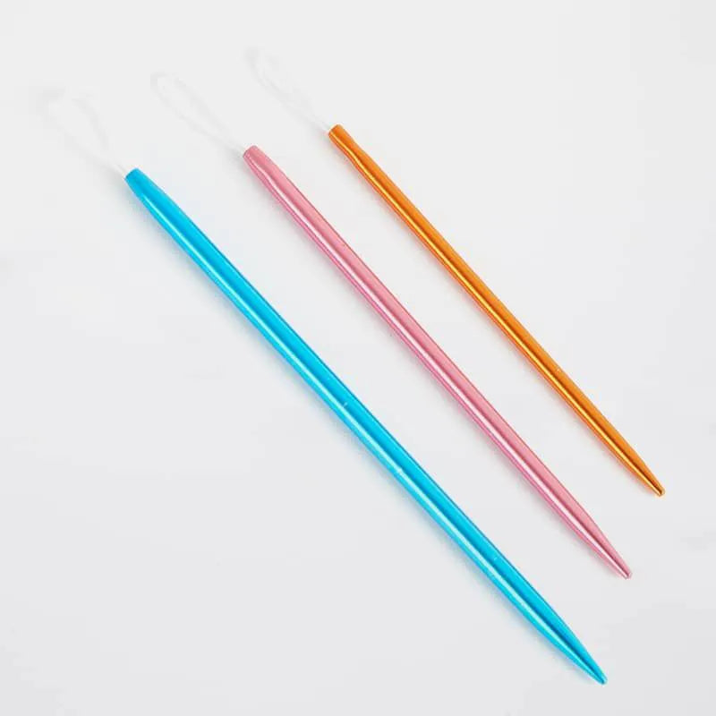 Three aluminum sewing up needles (blue, pink, orange) on a light gray background