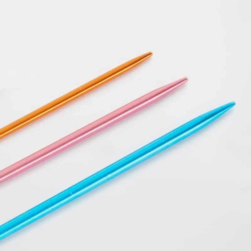 Three aluminum sewing up needles (blue, pink, orange) close up on tips