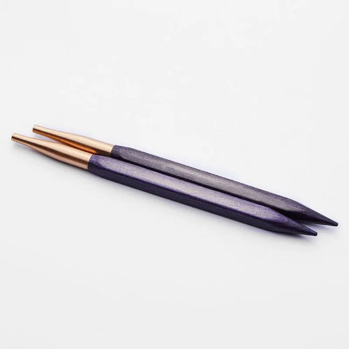 Two purple knitting needles with rose gold accents on a white background