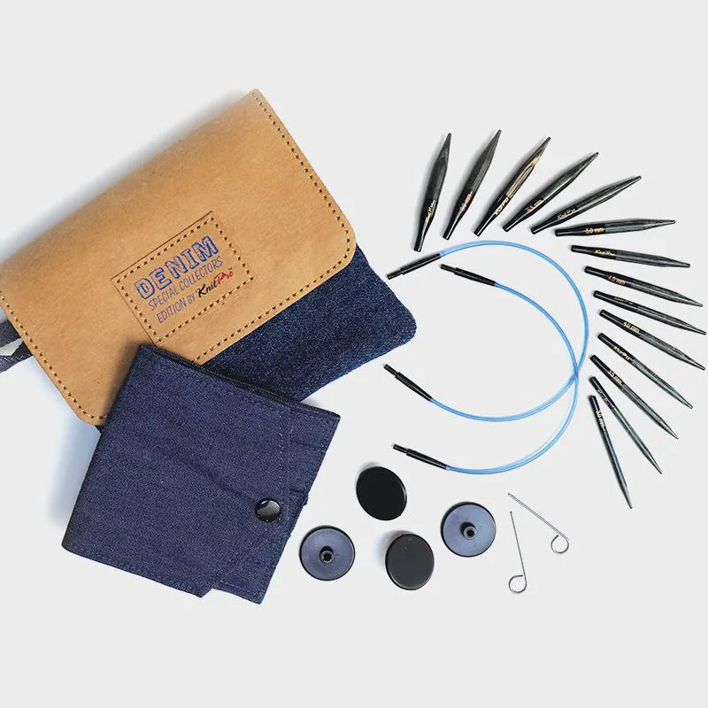 Knitting needle set with blue cables, black components, and denim and beige cases on a light gray background
