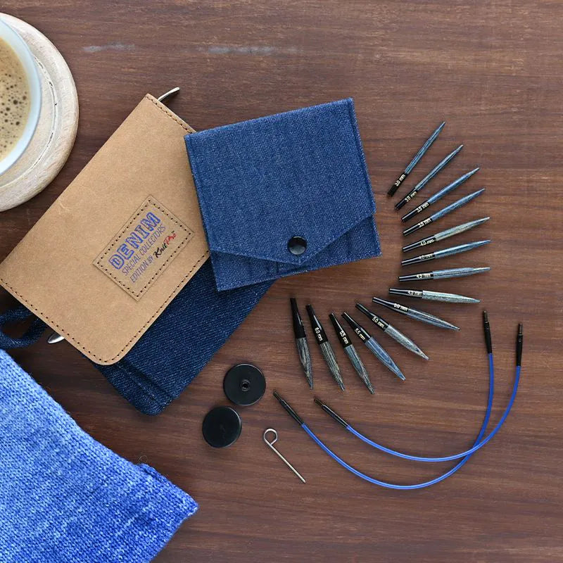 Collection of knitting needles and accessories on a wooden surface