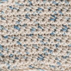 Close-up of a crocheted fabric with beige and blue pattern