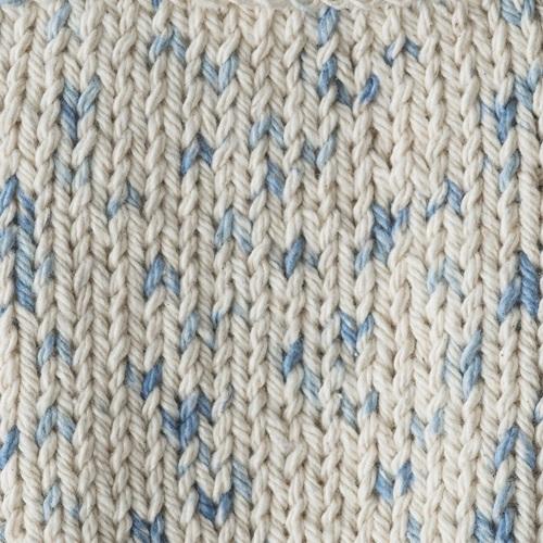 Close-up of a knitted fabric with a pattern of blue and beige yarn.