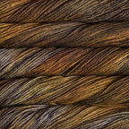 Close-up of multicolored Malabrigo Rios yarn with gold to brown hues.