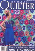 Magazine cover featuring a woman in a blue dress standing next to a colorful quilt with 'New Zealand Quilter' branding.