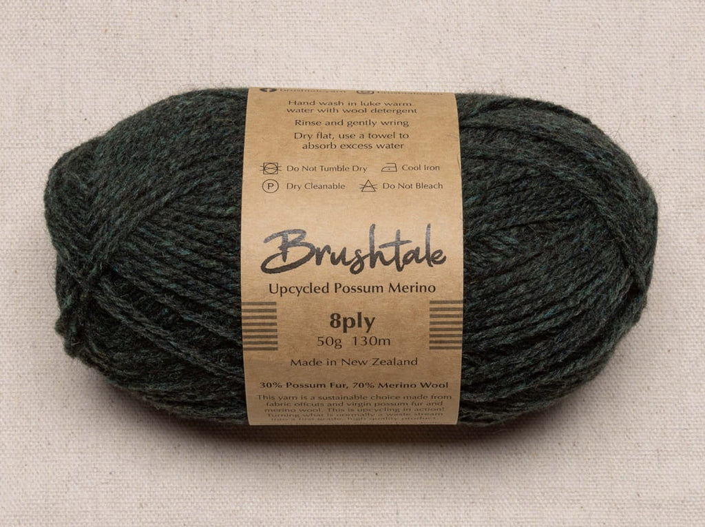 Close-up of dark forest green yarn with a tweedy texture