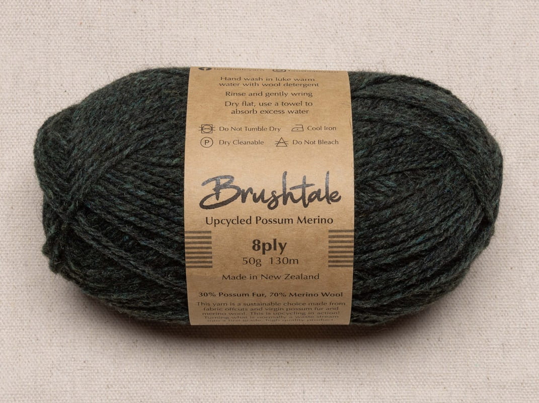 Close-up of dark forest green yarn with a tweedy texture