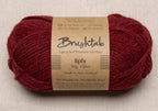 Close-up of red yarn with a tweedy texture