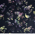 New Zealand designed quilt fabric with birds and floral elements in vibrant purples pinks and yellows on black
