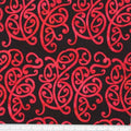New Zealand designed quilt fabric with Maori style swirls design in red on black 