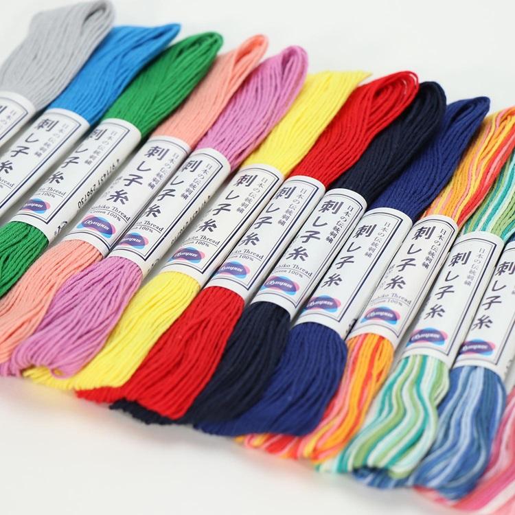 Assorted colorful Sashiko threads with labels on a white background