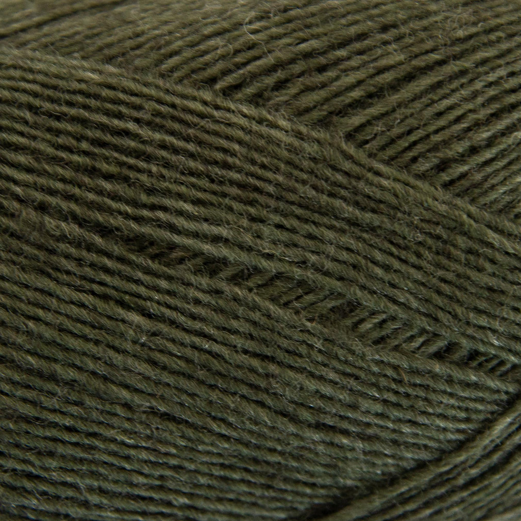 Close-up of a ball of dark green yarn with a textured pattern